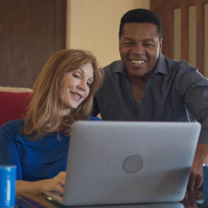 two adults looking at a computer screen