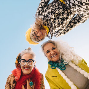 three women 50+ years old smiling together